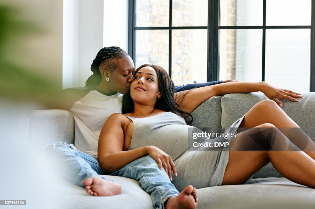 Pregnant lesbian couple relaxing on sofa