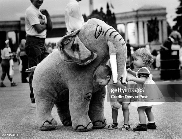 The Festival of Mountains andPlains Jessie Yager ducks under the trunk of a hugh stuffed elephant as Lindsay Plutt stands near by. The elephant was...