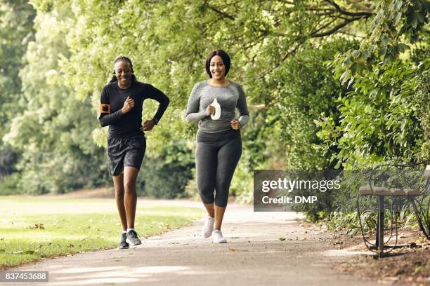 twee vrouwen lopen in het park - running in park stockfoto's en -beelden