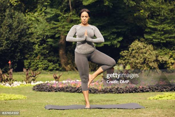 woman practicing yoga in the park - tree position stock pictures, royalty-free photos & images