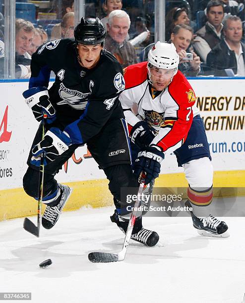 Vincent Lecavalier of the Tampa Bay Lightning controls the puck behind the net against Keith Ballard of the Florida Panthers at the St. Pete Times...