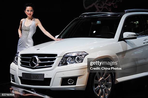 Model poses beside a Mercedes-Benz GLK300 car at the Auto Guangzhou 2008 Exhibition on the media day November 18, 2008 in Guangzhou of Guangdong...