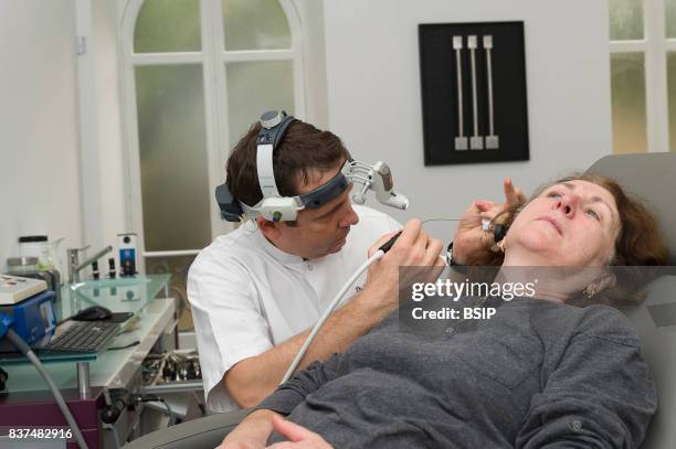 Doctor treating patients suffering from dizziness, Nice France, The doctor removes a plug of earwax.