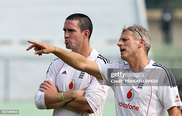 England cricket coach Peter Moores gestures as he talks with captain Kevin Pietersen during a training session at Green Park stadium in Kanpur on...