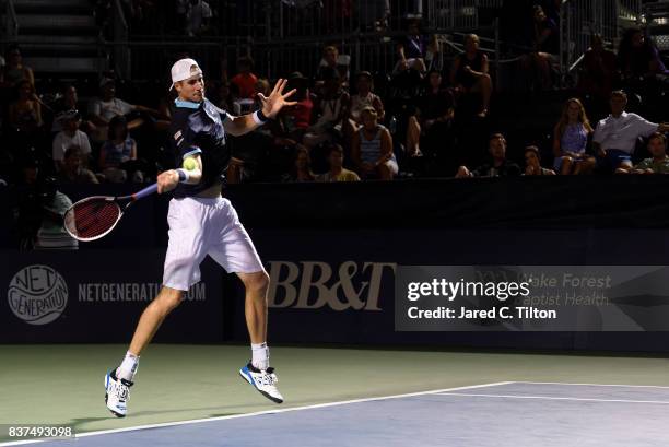 John Isner returns a shot from Andrey Kuznetsov of Russia during the fourth day of the Winston-Salem Open at Wake Forest University on August 22,...