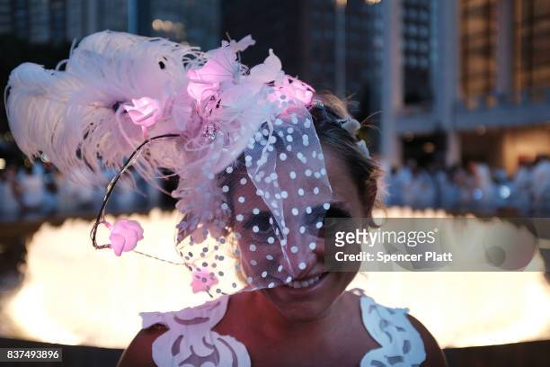 Woman pauses during the annual "Diner en Blanc" at Lincoln Center on August 22, 2017 in New York City. Diner en Blanc began in France nearly 30 years...