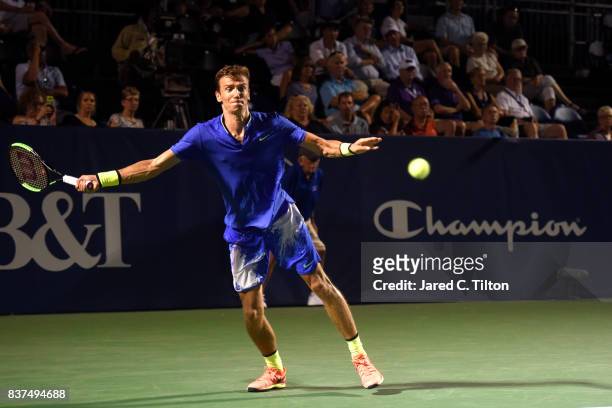 Andrey Kuznetsov of Russia returns a shot from John Isner during the fourth day of the Winston-Salem Open at Wake Forest University on August 22,...