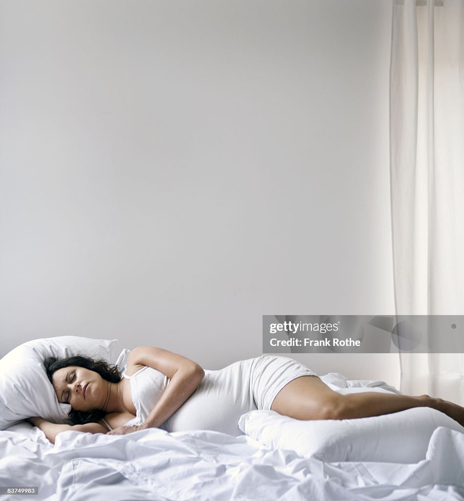 Pregnant woman lying in bed