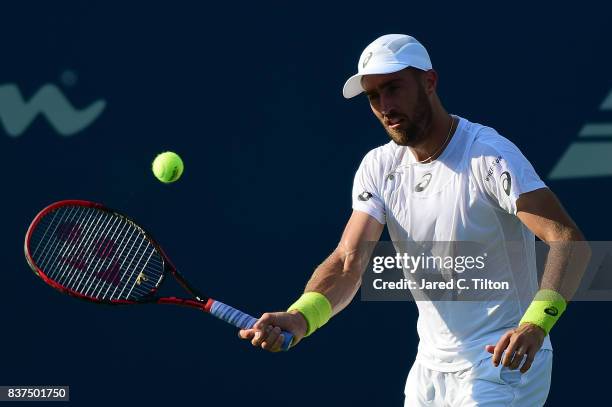 Steve Johnson returns a shot from Yen-Hsun Lu of Chinese Taipei during the fourth day of the Winston-Salem Open at Wake Forest University on August...