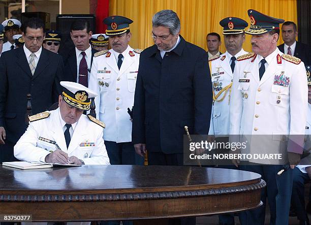 Rear Admiral Cibar Ezequiel Benitez signs as new Commander in Chief of the Paraguayan Army Forces next to Paraguay's President Fernando Lugo and the...