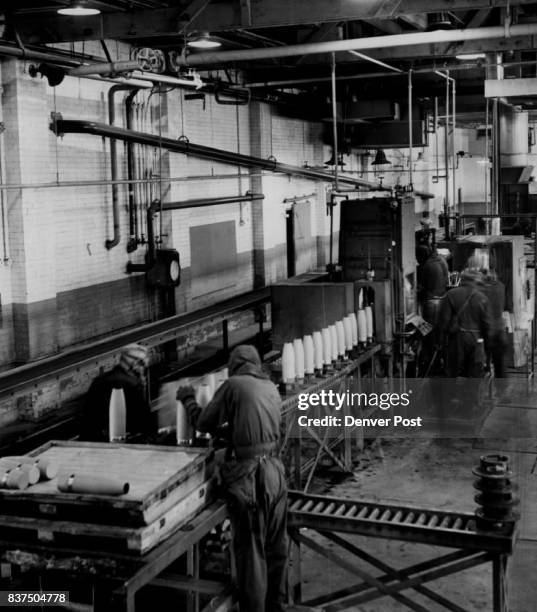 Above is the mustard gas assembly line where arsenal employes fill 105-mm. Artillery shell casings with deadly gas. Photo at left shows the casings....