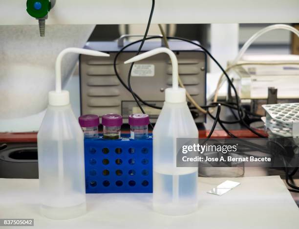 desk with bottles and pipes of liquids in a laboratory of molecular biology. spain - laboratory shaker stock pictures, royalty-free photos & images