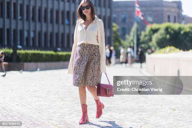 Darja Barannik wearing white blouse, skirt, red Gucci bag and red boots outside IBEN on August 22, 2017 in Oslo, Norway.