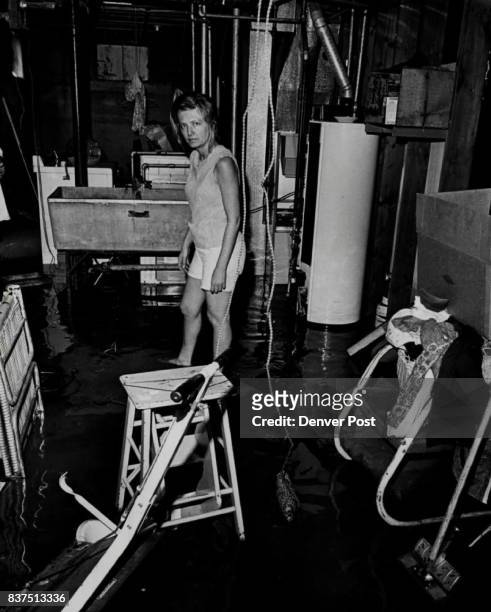 Mrs. Jackie Oughtred, 3324 W. 21st ave., Stands, Ankle-Deep In Water The clear water filled her basement after earlier backup of raw sewage receded....
