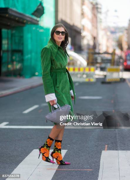 Darja Barannik wearing Balenciaga bag, green coat, Balenciaga sock boots outside Moods of Norway on August 22, 2017 in Oslo, Norway.