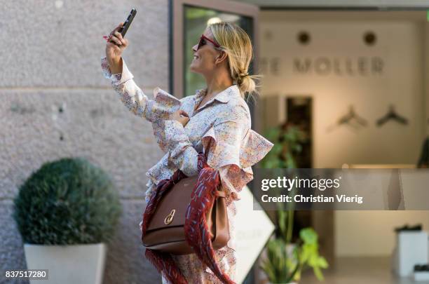 Janka Polliani taking a photo wearing a dress, brown Mulberry bag outside Moods of Norway on August 22, 2017 in Oslo, Norway.