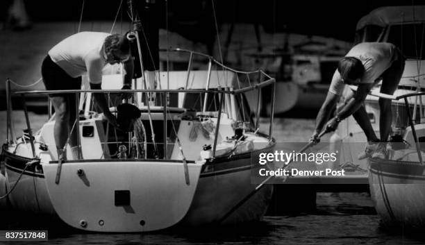 Ted Holmes, left, and Jerry Busch scrub down their Merit 25 at the Dillon Yacht Club docks. Credit: The Denver Post