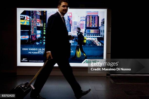 Man passes in front of a Alitalia advertising board in Linate airport, during the strike of Alitalia workers in Linate airport on November 11, 2008...
