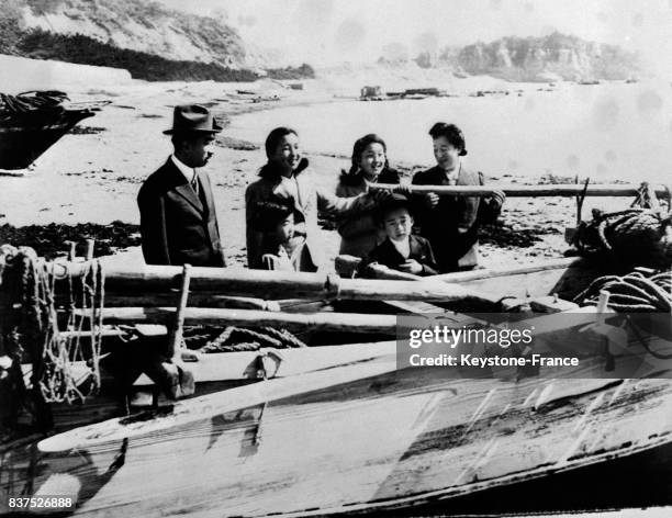 Empereur Hirohito, sa femme et ses deux filles examinent une vieille barque de pêche qu'il souhaiterait acquérir pour sa collection, au Japon en 1946.