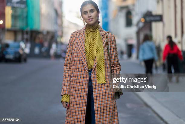 Darja Barannik wearing a plaid coat, yellow button shirt, white boots, cropped denim jeans outside Line of Oslo on August 22, 2017 in Oslo, Norway.