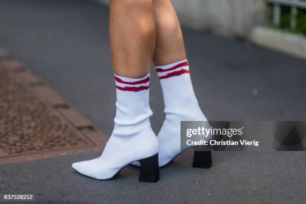 Guest wearing a red dress, white sock boots, Chanel bag outside Line of Oslo on August 22, 2017 in Oslo, Norway.