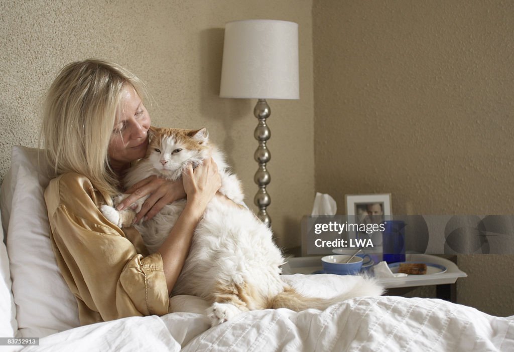 Woman Holding Cat in Bed