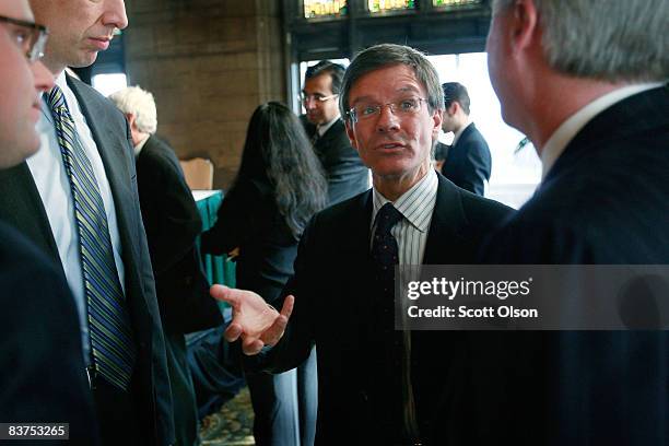 Thomas Wilson, chairman, president and CEO of The Allstate Corporation, speaks with guests following a panel discussion on the global financial...