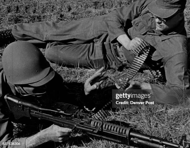 Two Seabees, Electrician 1.C. Robert Standage, left, and Electrician 2.C. Edward Otto Moellmar, fire blanks from an M60 machine gun during Viet Cong...