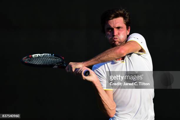 Gilles Simon of France returns a shot from Damir Dzumhur of Bosnia during the fourth day of the Winston-Salem Open at Wake Forest University on...