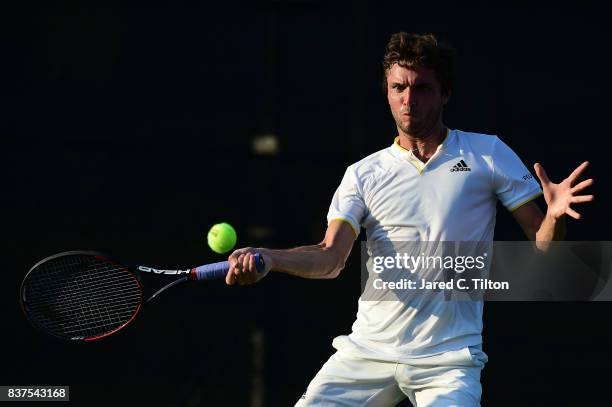 Gilles Simon of France returns a shot from Damir Dzumhur of Bosnia during the fourth day of the Winston-Salem Open at Wake Forest University on...