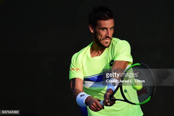 Damir Dzumhur of Bosnia returns a shot from Gilles Simon of France during the fourth day of the Winston-Salem Open at Wake Forest University on...
