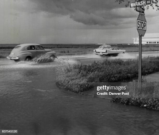 Sloppy Sailing in East Denver Cars churn up the water in a quick-forming pond at Mont-view Blvd. And Wabash St. Late Saturday afternoon after a...