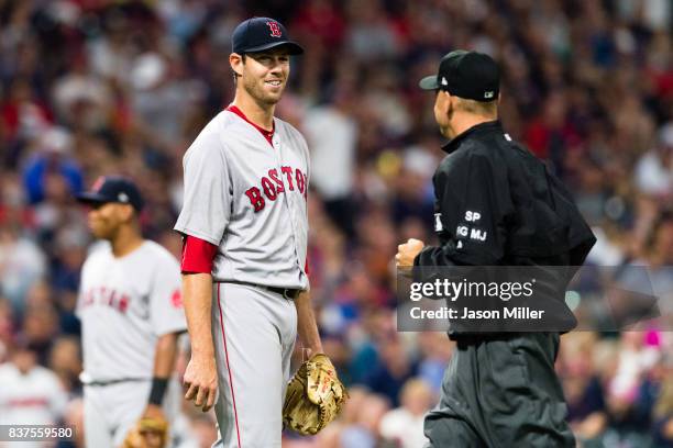 Starting pitcher Doug Fister of the Boston Red Sox jokes with second base umpire Andy Fletcher as Fletcher runs in for a review during the second...