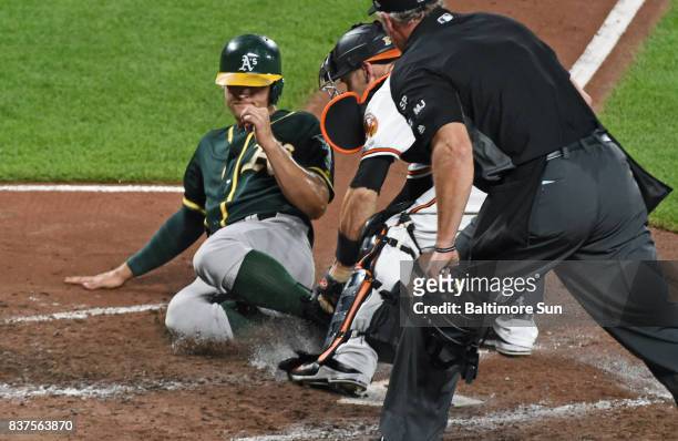The Oakland Athletics' Chad Pinder, left, is tagged out by Baltimore Orioles catcher Caleb Joseph on a fielder's choice in the eighth inning at...