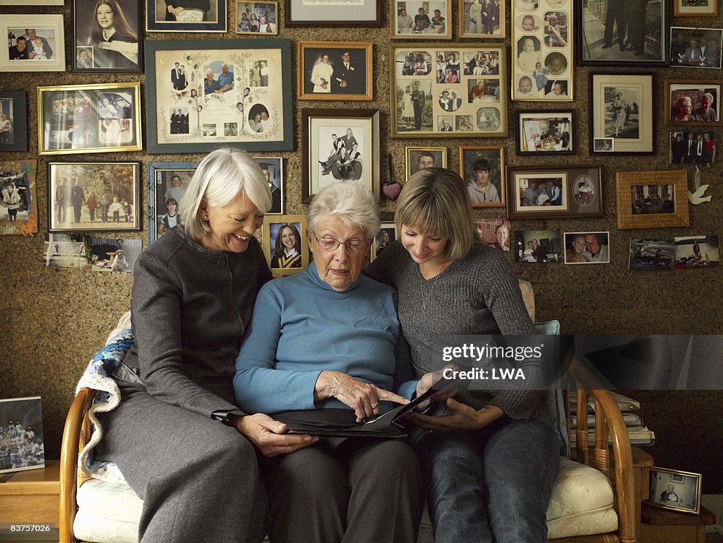 Three Generations of Women Looking at Photo Album