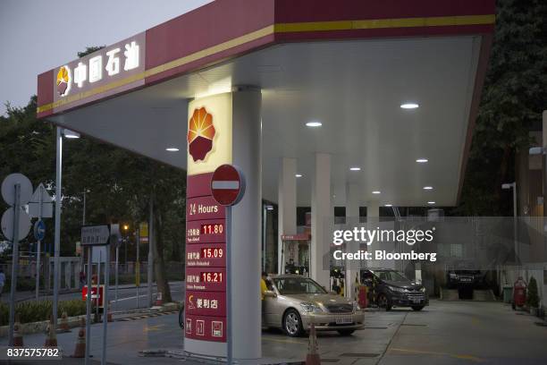 Vehicles stand while being refueled at a PetroChina Co. Gas station at dusk in Hong Kong, China, on Monday, Aug. 21, 2017. PetroChina is scheduled to...