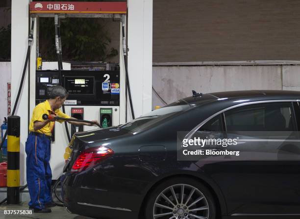 An employee refuels a vehicle at a PetroChina Co. Gas station at night in Hong Kong, China, on Monday, Aug. 21, 2017. PetroChina is scheduled to...
