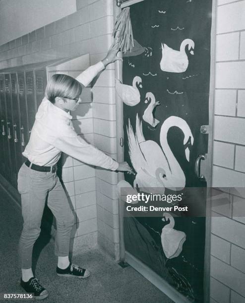 Dan Lere, son of Mr. And Mrs. Raymond Lere, 901 Hanover St., checks over swan decoration on door for "Twelve Days of Christmas" at West Junior High...