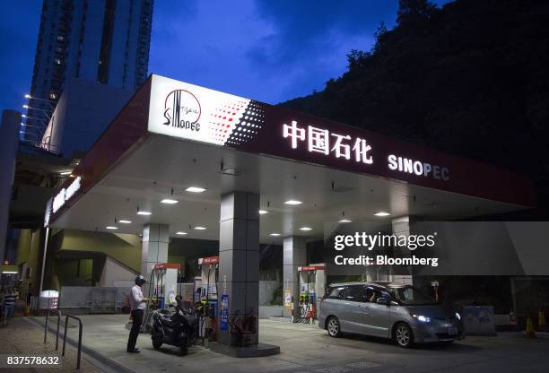Vehicles refuel at a China Petroleum & Chemical Corp. Gas station at dusk in Hong Kong, China, on Tuesday, Aug. 22, 2017. Sinopec is scheduled to...