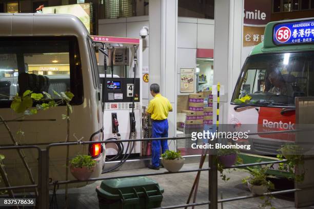 An employee stands near gas pumps at a PetroChina Co. Gas station at night in Hong Kong, China, on Monday, Aug. 21, 2017. PetroChina is scheduled to...