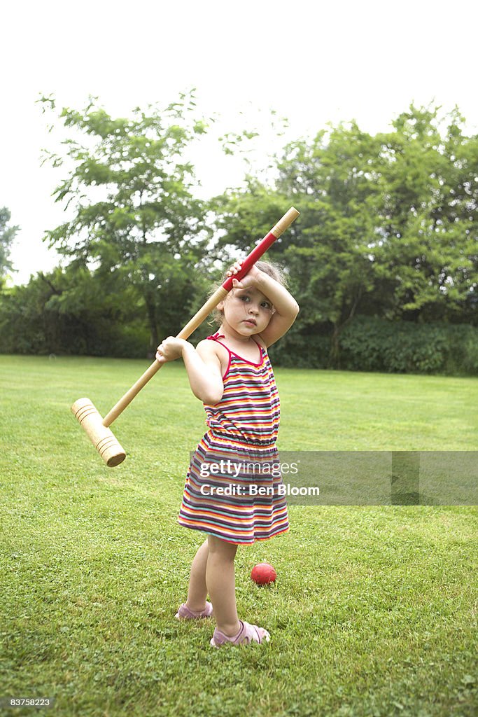 Girl with croquet mallet and ball