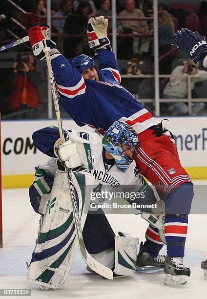 Goaltender Roberto Luongo of the Vancouver Canucks ducks under Aaron Voros of the New York Rangers November 19, 2008 at Madison Square Garden in New...