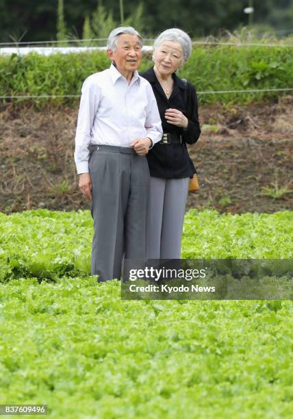 Japanese Emperor Akihito and Empress Michiko stroll in a lettuce field in Karuizawa, Nagano Prefecture, on Aug. 23, 2017 during their six-day visit...