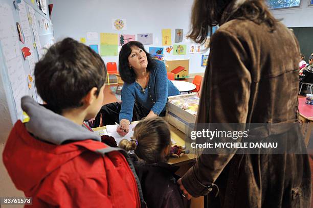 Mother takes her childREN to a temporary daycare center set up on Novembre 20 in Herouville-Saint-Clair, northwestern France, on a national teachers'...