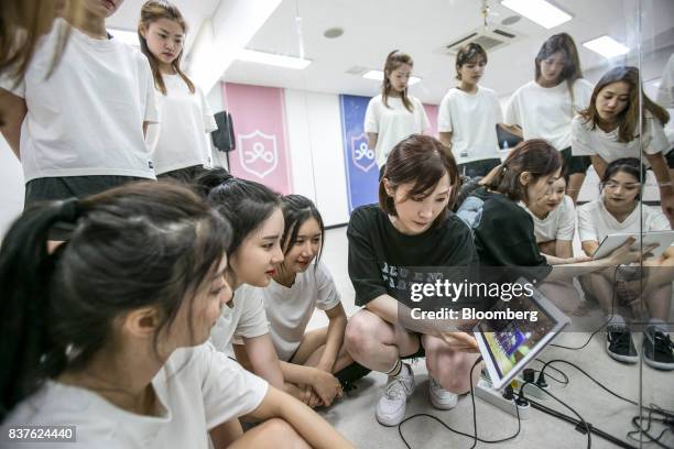 Dance instructor, center, and contestants watch a video during a dance practice session during the production of the "Idol School" reality television...