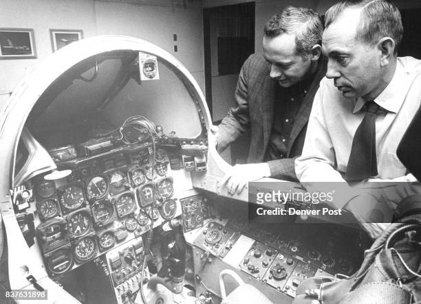 Ed Fitzpatrick, field engineer for ACF Electronics, Riverdale, Md., technical representative at Buckley Field, examines F100 simulator with M. Sgt....