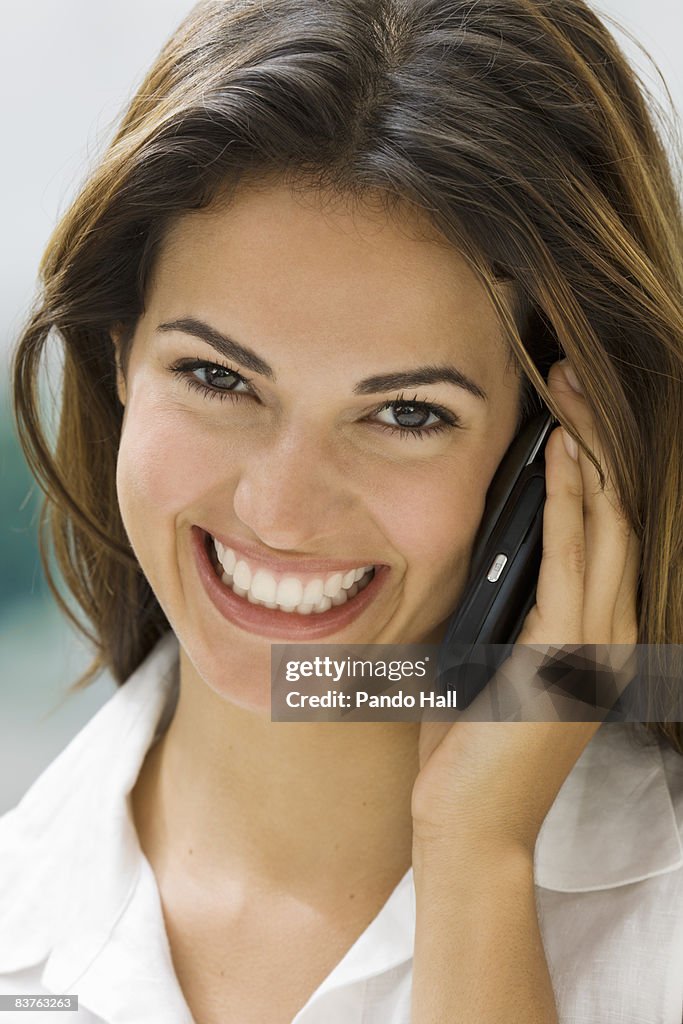 Young Woman using mobile phone, smiling