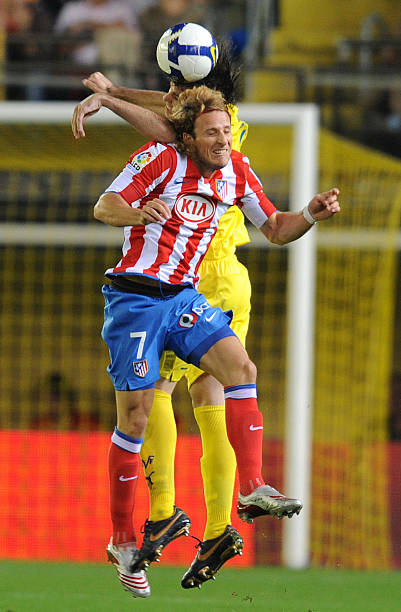 Villarreal's Uruguayan Diego Godin jumps for a header with Atletico Madrid's Uruguayan Diego Forlan during their Spanish league football match at the...