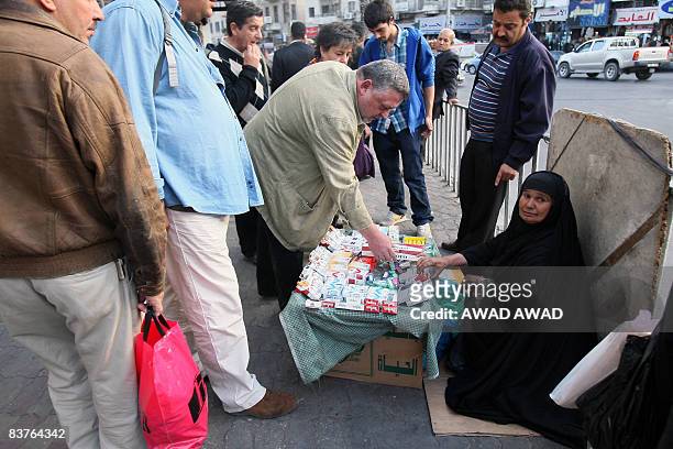 An Iraqi refugee woman sells cigarettes on the side of a road in the Jordanian capital Amman on November 20, 2008. The Iraqi embassy in Amman...