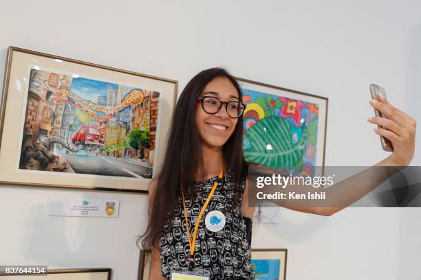 Victoria Bezerra Oliveira of Brazil, gold award winner of age 12 to 15 category for 'The Recycle of Dreams', takes selfie during the 11th Toyota...